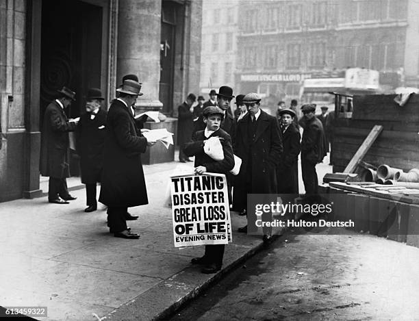 Men buy newspapers from a newsboy on a city street carrying the headline: "Titanic Disaster Great Loss of Life"