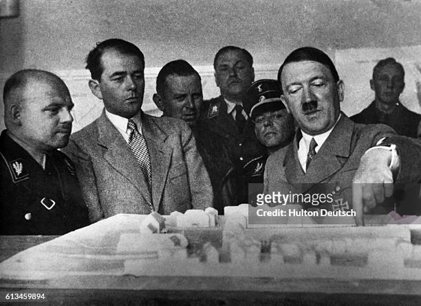 The German Chancellor Adolf Hitler, accompanied by Governor Saukel on his right, and Albert Speer discusses plans for a new administration building...