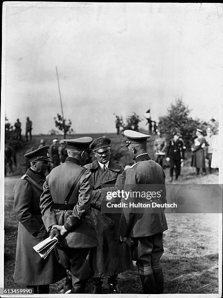 During practice maneuvers, Adolf Hitler talks to Generals Werner von Blomberg, Werner Von Fritsch, and Wilhelm Ritter von Leeb. | Location: Hanover,...