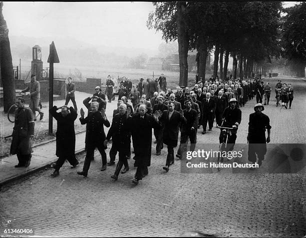 Allied soldiers march a group of Dutch prisoners of war through the town of Nijmegen after the capture of the Nijmegen Bridge.