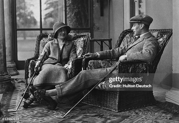 Albert and Elizabeth, Duke and Duchess of York, relax after a round of golf during their honeymoon. They are the future King George VI and Queen...