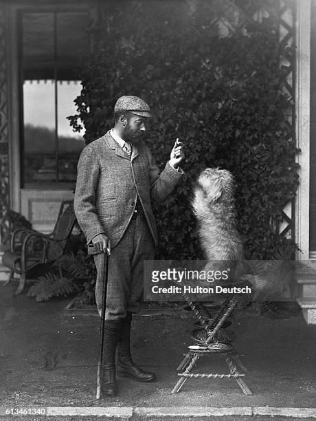 George, Duke of York, the future King George V of England, plays with a pet dog.