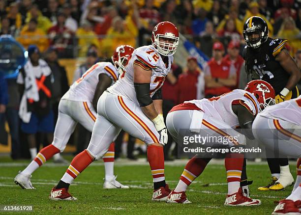 Offensive lineman Eric Fisher of Kansas City Chiefs looks on from the field as linebacker Jarvis Jones of the Pittsburgh Steelers looks across the...