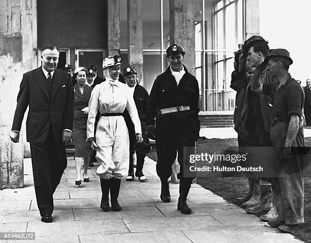 The Queen wearing miners overalls is accompanied by workers before descending the mine at Rothes Colliery in Fife during a visit to the area.