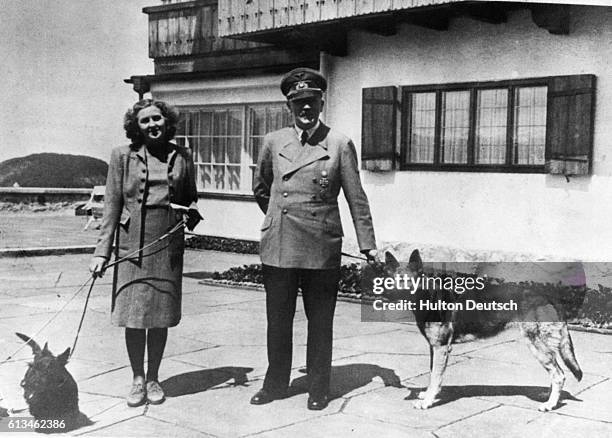 The German Chancellor Adolf Hitler and his mistress Eva Braun with their dogs at Bertesgaden, ca. 1935.