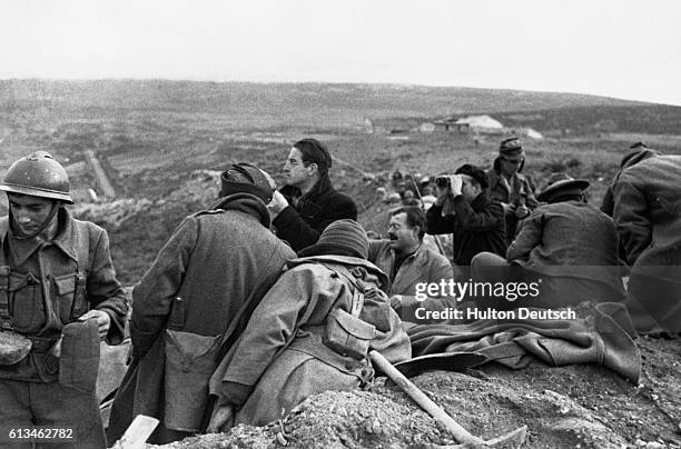 Group of war correspondents gather in a Spanish trench while covering action in the Spanish Civil War. American writer and journalist Ernest...