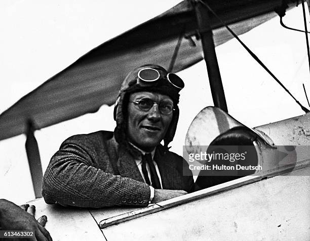 English aviator Sir Francis Chichester sits in the cockpit of his biplane after flying to Sydney.