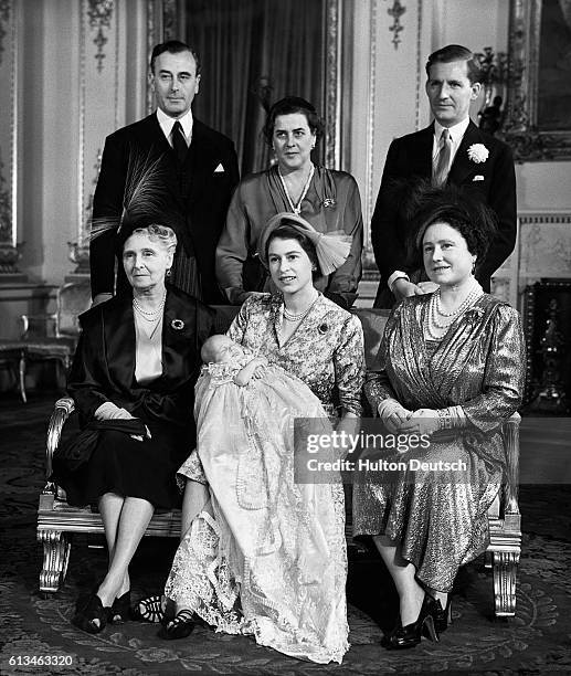 Princess Elizabeth holds her daughter Princess Anne after her Christening at Buckingham Palace, accompanied by members of the family, including the...