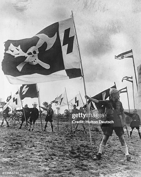 Nazi youths display flags in an open air camp near Berlin. From the sixth year of age, German boys have to join the Nazi organization of youth....