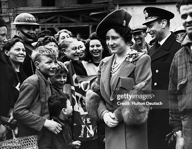 King George VI and Queen Elizabeth of England tour blitzed areas of east London during World War II.