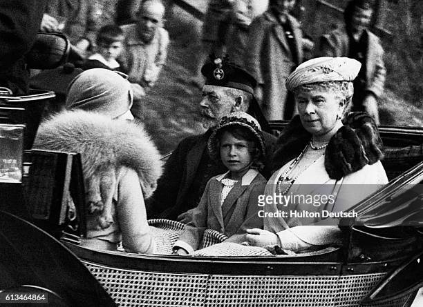 Princess Elizabeth sits between her grandparents, King George V and Queen Mary of England, facing her mother Elizabeth, the Duchess of York, as the...