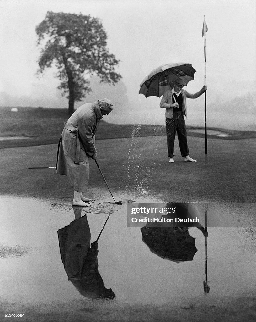 Men Golfing on Wet Putting Green