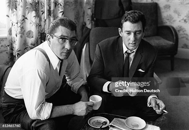 Brothers Ronnie and Reggie Kray drink tea at home in London after spending 36 hours helping the police with their enquiries regarding the murder of...