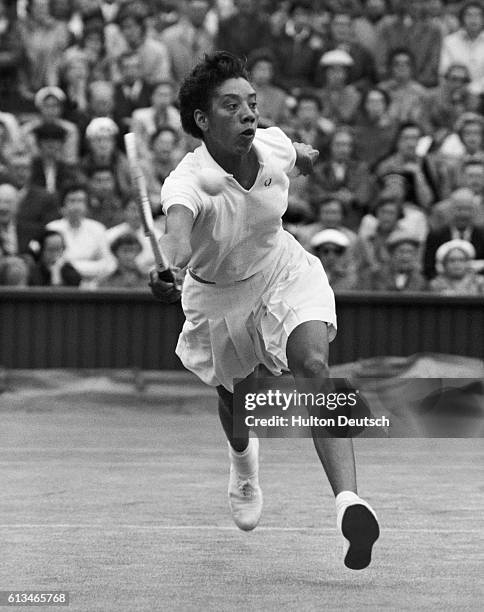 Tennis player Althea Gibson hits the ball during a match at the 1956 Wimbledon Championships.