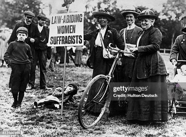 Suffragettes who cycled from various parts of England to London to attend a 1913 meeting, advertise that they are law abiding, so as to distinguish...