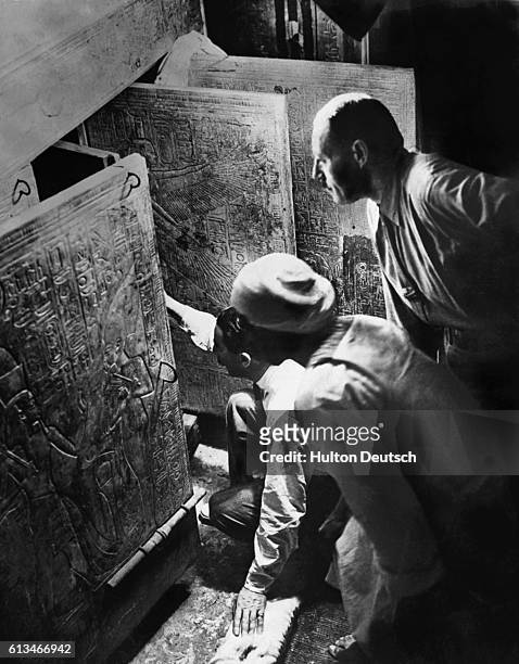 Howard Carter and A.R. Callender, who discovered the stone sarcophagus, open Tutankhamun's tomb in the Valley of the Kings, Egypt, in 1922.
