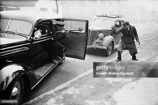 Scotland Yard officials testing armoured vehicles in a mock-up of chase and battle, London, 1937. | Location: Scotland Yard, London, England, UK.