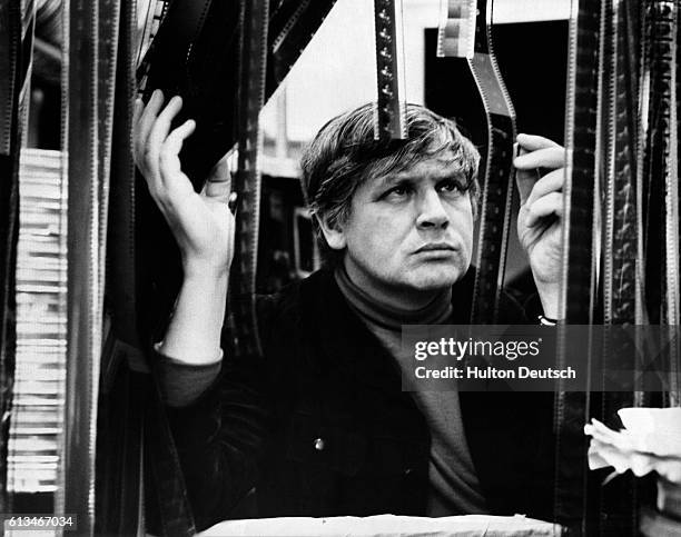 English film and television director Ken Russell scrutinizing film negatives, 1966.