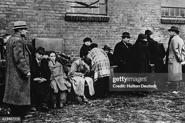 Group of expelled Polish Jews resting outside a stable at Zbonszyn on the Polish-German frontier. Over 7,000 of them have been expelled from Germany...