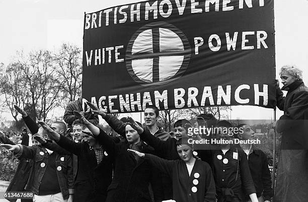 Young skinheads give a Nazi salute as they participate in a British Movement march between Paddington and Marble Arch. London, 1980.