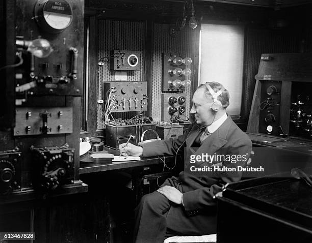 Physicist Guglielmo Marconi at work in the wireless room of the yacht Electra. Guglielmo invented wireless communication in the late 1800s and later...