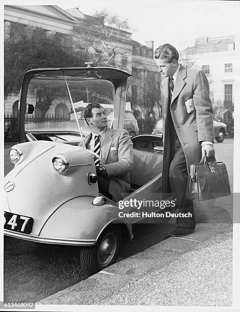 Mr E. A. Hawkins tries out the Messerschmitt Cabin Scooter under the help of Brian Calbert. Small cars have become more popular since the...