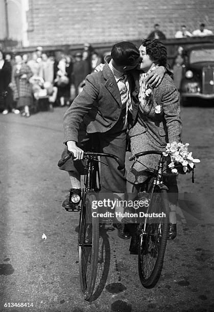 Lelise Seymour and Daisy Burgess exchange a kiss after their marriage at Hendon Registry Office before cycling to the Passport Office to collect the...