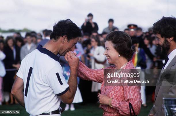 Prince Charles kisses the hand of his mother, the Queen, after the Cartier Polo Match.