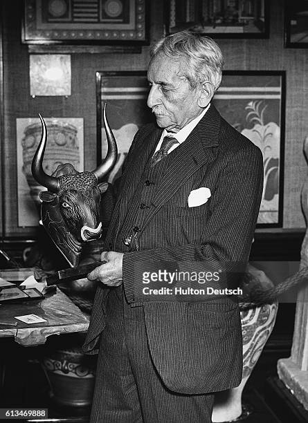 The archaeologist Sir Arthur Evans examines a Cretan bull's head at an exhibition of relics from Knossos at the Royal Academy.