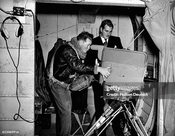 Duncan Anderson operates a Marconi image Orthicon camera as Peter Dimmock provides commentary for a BBC broadcast from a Bristol freighter of a scene...