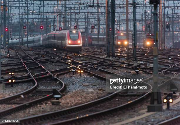 commuter train approaching busy railway track field at twilight - metra train stock pictures, royalty-free photos & images