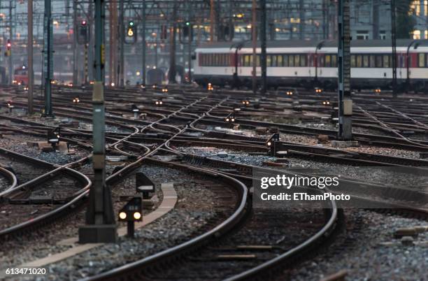 commuter train leaving busy railway track field at twilight - weichen gleise stock-fotos und bilder