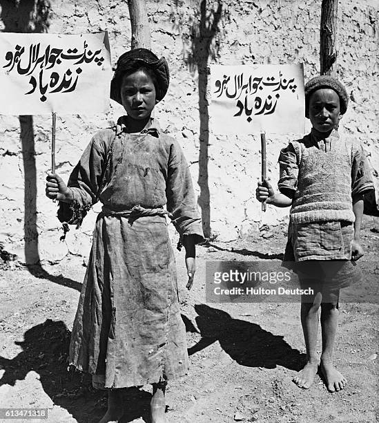 Two children from the disputed Ladakh region carry signs pledging their allegiance to India and Prime Minister Nehru during the 1962 border war...