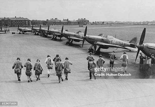 Pilots of No.111 Squadron Royal Air Force Fighter Command make a practice scramble to board their Hawker Hurricane Mk.1 monoplane fighters with their...