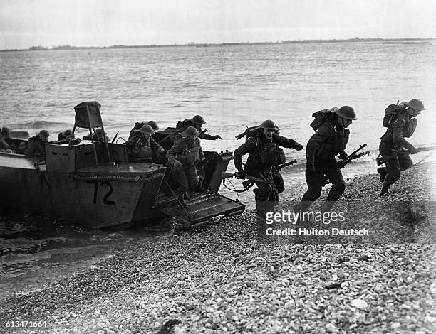 The Infantry Of The Navy. During strenuous exercises Royal Marines leap from a landing barge armed with Bren-guns, rifles and anti-tank rifles.