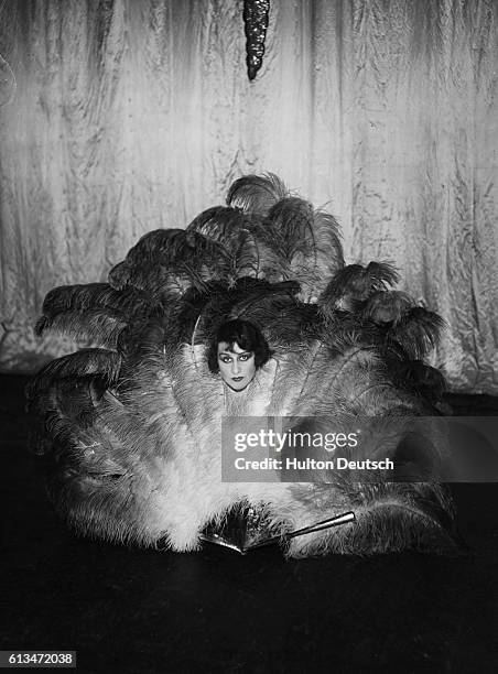Music hall actress Jenny Golder surrounded by ostrich feathers whilst starring in the revue Palace Aux Femmes at the Palace in Paris, ca. 1925.