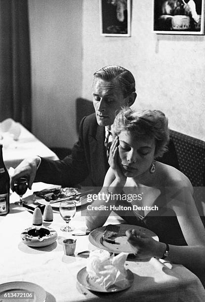 In a scene staged by the Picture Post for a series on romance, marriage, and divorce, a young French woman is bored by her date, "a typical English...