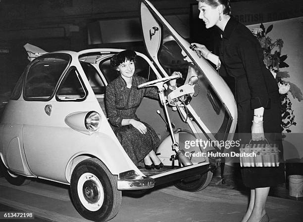 Two women take a look at the new BMW Isetta bubble car at the Earls Court Motor Show in 1955.