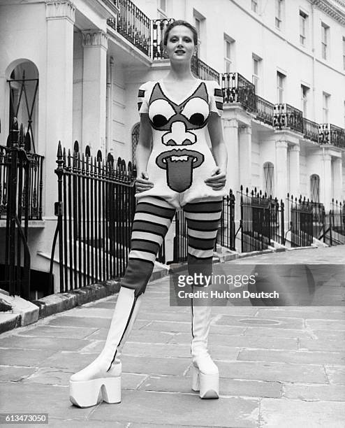 Caroline Coon models white, platform boots and a red-and-white, hand-knitted, woollen, jump suit, by the Japanese designer, Kansai Yamamoto. London,...