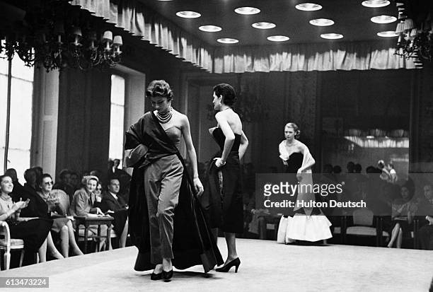 Models parade in evening wear at a fashion show in Florence. Italy, 1951.