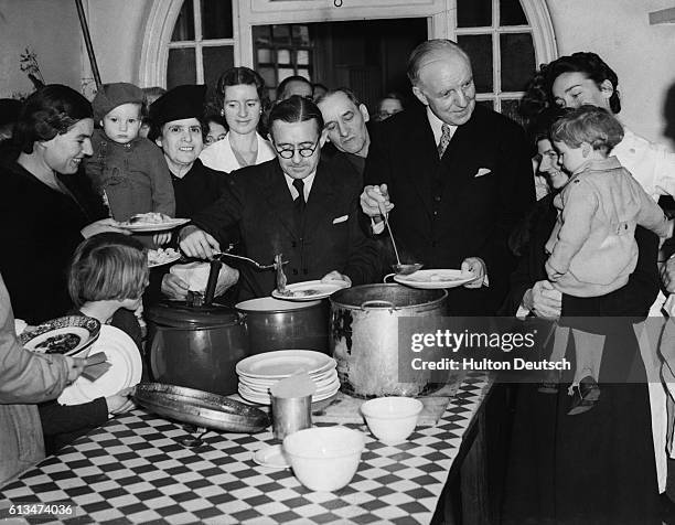 Lord Woolton, British Minister of Food, serves up food to young diners at a mobile field kitchen in England during World War II.