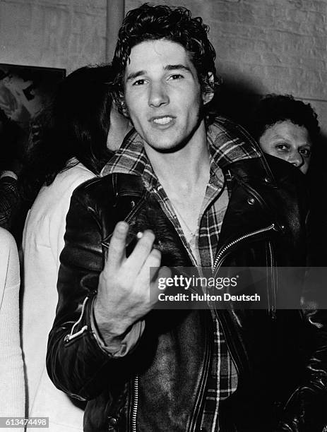 American actor Richard Gere gesturing at a cameraman at a party to celebrate the opening of the stage show 'Grease', London, 1973. | Location: Kings...