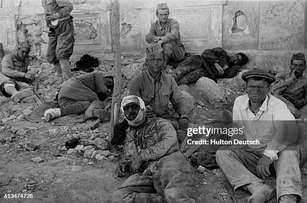 Group of Russian soldiers rests on a pile of rubble in the ruined streets of Stevastopol after a difficult but successful battle.