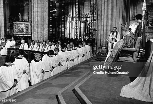 Dr. Robert Runcie, the Archbishop of Canterbury, conducts the investiture of the Church of England's first women priests.