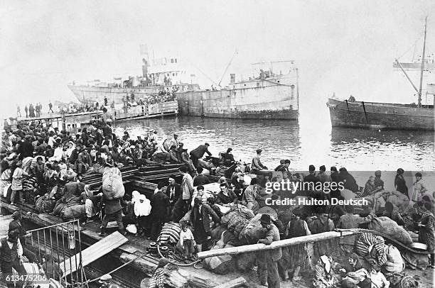 Greek refugees board a passenger vessel following the destruction of Smyrna.