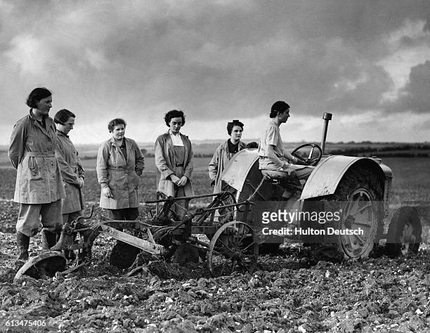 Members of the Women's Land Army stop their work in the fields to observe the one minute silence, November 1939.