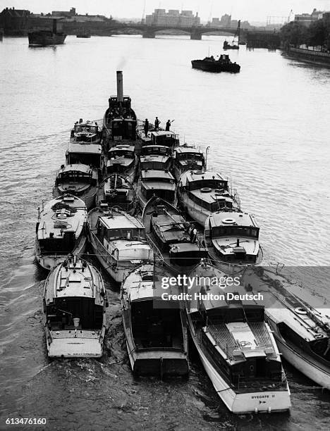 Barge tows several small boats up the Thames for repairs after they were used in the emergency evacuation of French and British troops at Dunkirk in...