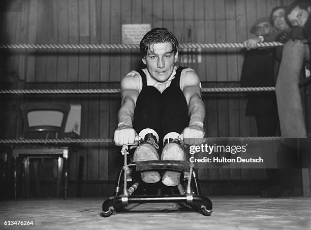 Boxing champion E. Boon grits his teeth as he exercises on a rowing machine.