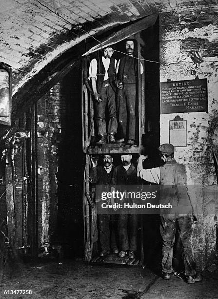 Miners descend to the pits in elevators at the start of their shifts.