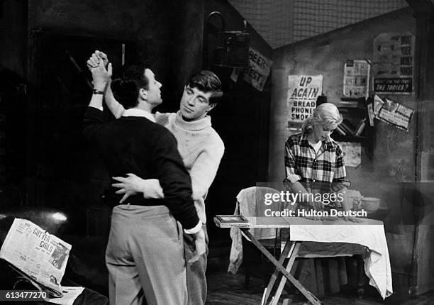 Jimmy Porter, played by Kenneth Haigh dances with his friend Cliff whilst his wife Alison does the ironing in a scene from John Osborne's 1956 play...